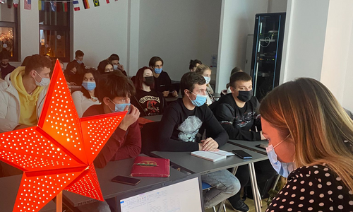 Zdjęcie przedstawia wykładowcę i studentów podczas warsztatów z języka polskiego
