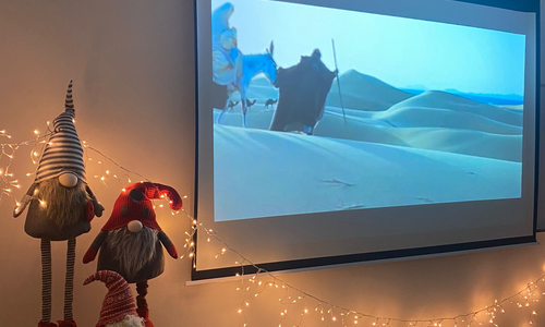 Zdjęcie przedstawia ekran projektora i dekoracje świąteczne